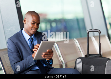black businessman using tablet computer at airport Stock Photo