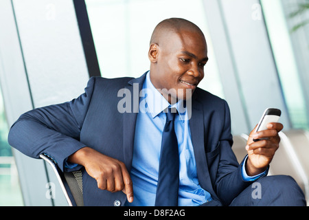 handsome african american businessman using smart phone emailing Stock Photo