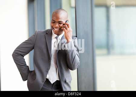 happy african american businessman talking on mobile phone in modern office Stock Photo
