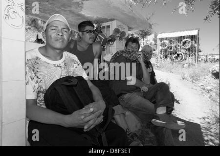 April 25, 2013 - Nogales, Sonora, Mexico - A group of men, half from Honduras and half Mexican nationals, rest in a cemetery in Nogales, Son. Mex. Both Mexican nationals were recently deported from the U.S. and are weighing their options for a return.  FRANKLIN  ALEXANDER ORDONEZ ORDONEZ, left, 29, is from Honduras on his way north and said he would be trying a fourth time to enter the county in search of work following three deportations. Ordonez said another Border Patrol arrest would not be enough to discourage him.The other Honduran voluntarily left Northern California to return home for h Stock Photo