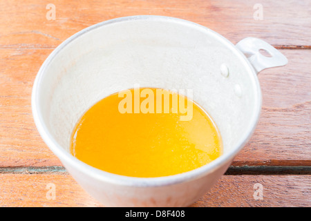 Bakery melt butter measured in plastic cup Stock Photo