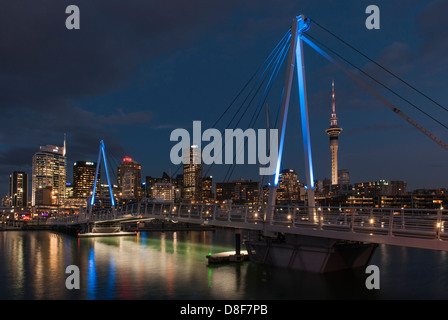 Wynyard Crossing, the lifting bridge between Wynyard Quarter and Viaduct Marina, downtown Auckland CBD and Sky Tower in background, early evening. Stock Photo