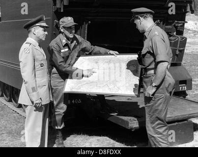 American military governor of Berlin John F. Franklin (l), commander of US brigade of Berlin General John H. Hay (m) and British military governor David Peel Yates (r) inform themselves about the state of the joint manoeuvre of their troops in Grunewald in Berlin on the 3rd of September in 1964. Stock Photo