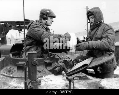 German tank soldiers study maps during their coffee break on the 10th of January in 1966. The soldiers and the tank are part of the German-American manoeuvre 'Silberkralle', in which 22,000 soldiers of the 3rd US tank division and 3,000 German soldiers of the 15th tank brigade Koblenz were involved. Stock Photo