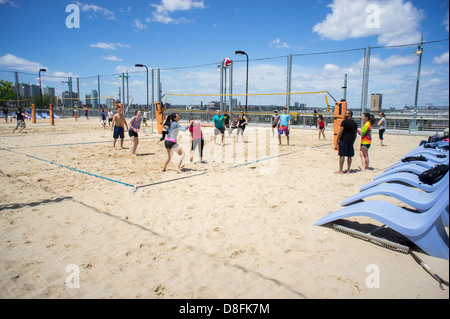 Sports enthusiasts play beach volleyball on the courts on Pier 25 in Sports enthusiasts play beach volleyball on the courts on Pier 25 in