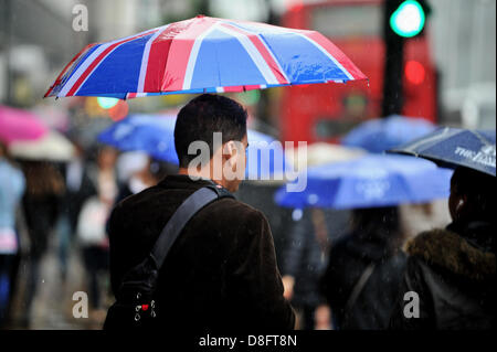 LONDON, UK. 28th May 2013. Heavy rain falls in London. A man joins a sea of umbrellas on Oxford Street, brandishing a Union Jack design. Credit: Polly Thomas / Alamy Live News Stock Photo