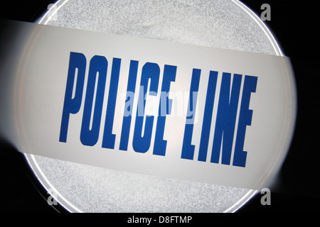 Police Line (Do Not Cross) tape from the United Kingdom (UK) in a spotlight. May 2013 Stock Photo