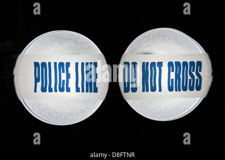 Police Line (Do Not Cross) tape from the United Kingdom (UK) in a pair of spotlights. May 2013 Stock Photo