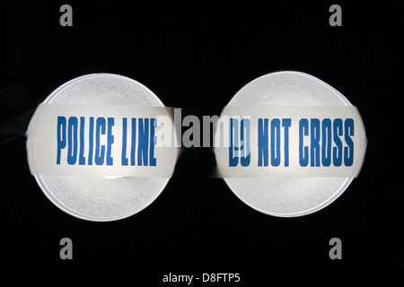 Police Line (Do Not Cross) tape from the United Kingdom (UK) in a pair of spotlights. May 2013 Stock Photo