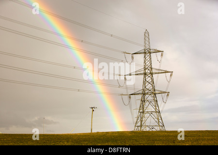 A rainbow over electricity pylons leaving Wylfa nuclear power station on Anglesey, Wales, UK. Stock Photo