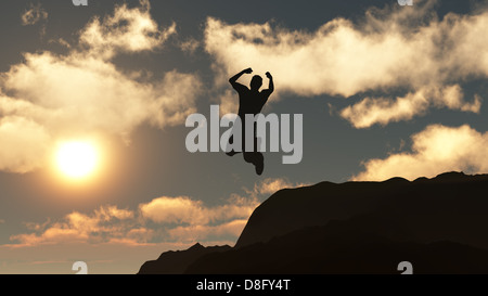 Silhouette of the jumping man from a rock Stock Photo