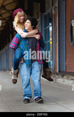 Young man giving a young woman a piggyback ride Stock Photo