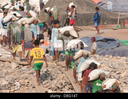 Laborers unloading barge on Ayeyarwaddy River near Mandalay, Myanmar. Stock Photo