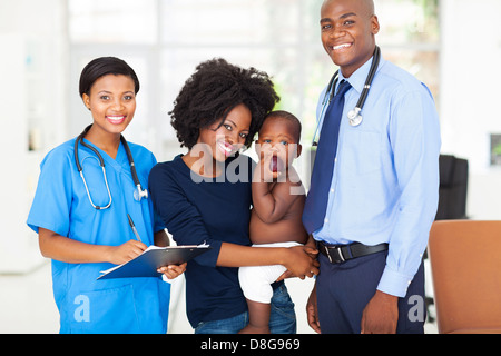 smiling pediatric medical professionals with african mother holding her baby Stock Photo