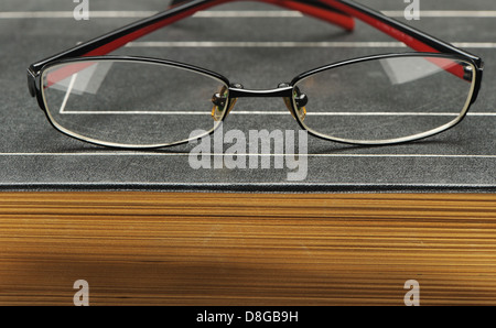Eyeglasses on the old thick book