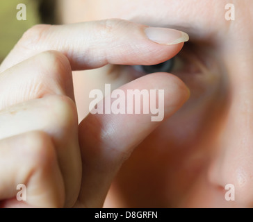 Fingers showing 'something little' - Blurred face in the background Stock Photo