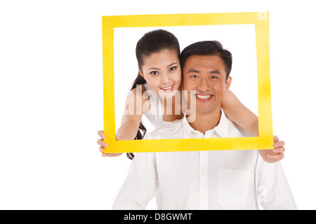 Young couple holding photo frame Stock Photo