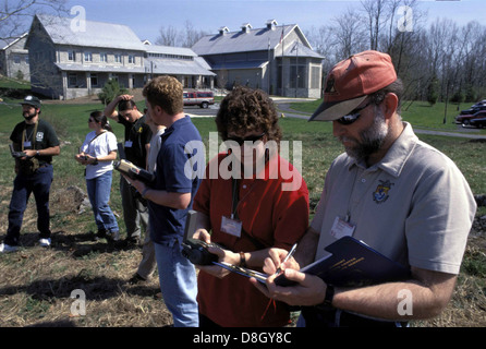 This image shows a group of students and a teacher participating in an outdoor class, likely in a field. The scene depicts learning in a natural setting, with students engaged in the lesson. Stock Photo