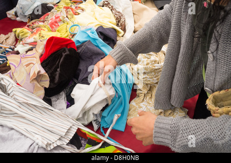 Female hands rummaging in clothes at a jumble sale Stock Photo - Alamy