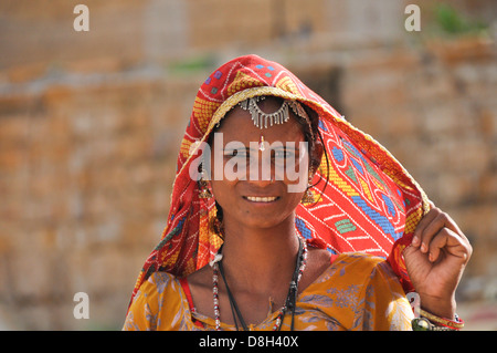Woman in traditional Rajasthani attire with mirror work seated on a ...