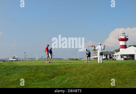 Golfers on 18th Hole at exclusive Habour Town Golf Links in Hilton Head South Carolina with famous red and white lighthouse Stock Photo