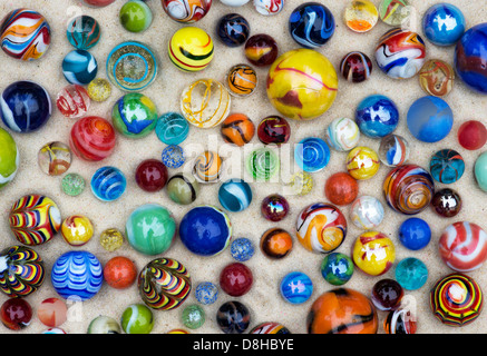 Colourful marbles on sand pattern Stock Photo