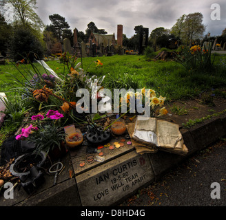 Gravestone of Ian Curtis, lead singer of the band Joy Division, in Macclesfield Cemetery, Cheshire, England, covered with flowers and personal tribute Stock Photo