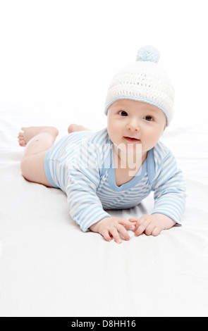 Beautiful baby boy in blue hat on the bed Stock Photo