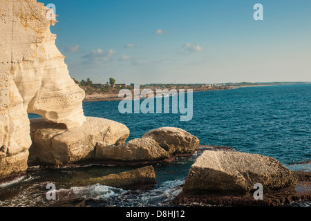 The northernmost shore of Rosh Hanikra, Israel, near the lebanese border. Israeli village in background. Stock Photo