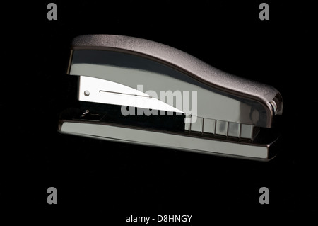Black stapler isolated against black backdrop Stock Photo