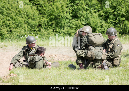 Overlord, D-Day re-enactment at Denmead 2013. Group of American soldiers sitting and talking whilst relaxing. Stock Photo