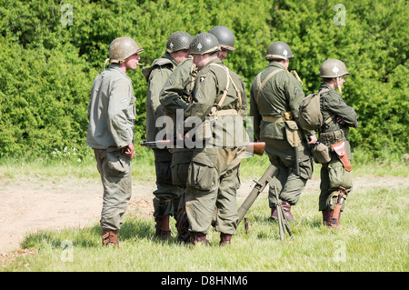Overlord, D-Day re-enactment at Denmead 2013. Group of American soldiers standing and talking whilst relaxing. Stock Photo