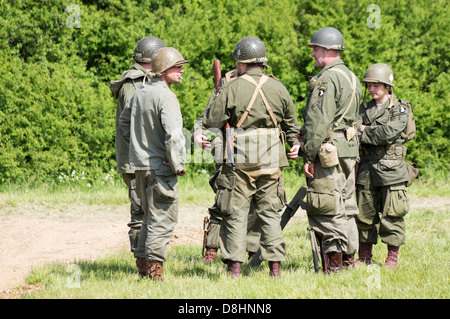 Overlord, D-Day re-enactment at Denmead 2013. Group of American soldiers standing and talking whilst relaxing. Stock Photo