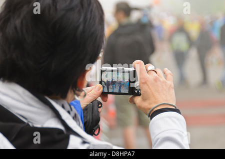 Man takes a picture with a digital point and shoot camera, people shown on the LCD monitor screen – picture in picture view Stock Photo