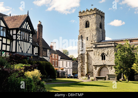 Holy Trinity Parish Church in the village of Much Wenlock, Shropshire, England. 16 C half-timbered Guildhall on left Stock Photo