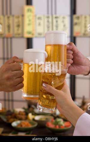 Three People Toasting with Beer and Chu-Hi at Izakaya Stock Photo
