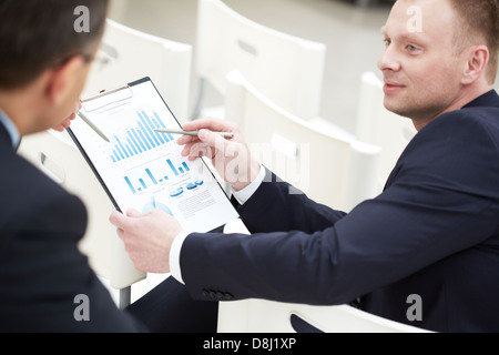 Close-up of two businessmen discussing paper Stock Photo