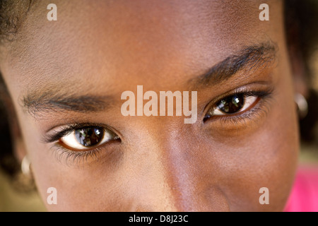 Closeup of eyes of pretty happy young african girl looking at camera and smiling
