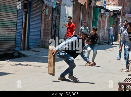 Srinagar,Indian Administered Kashmir, 30th May 2013. Kashmiri Muslim protesters throw stones towards Indian police during a protest in Srinagar, Jammu and Kashmir, India. Dozens of JKLF supporters held a protest on Thursday against the government's decision not to allow JKLF chairman Mohammad Yasin Malik to visit the earthquake-affected areas of the Doda region to distribute aid to victims.  (Sofi Suhail/ Alamy Live News) Stock Photo