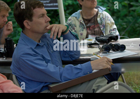 A man is focused and engaged during a class session, attentively listening to the instructor. The image reflects concentration and learning in an educational setting. Stock Photo