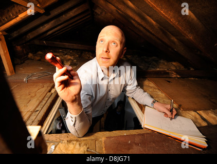 Energy Surveyor Mark Sopala inspects the loft at a domestic home in Bristol in order to optimise the heat efficiency of the hous Stock Photo