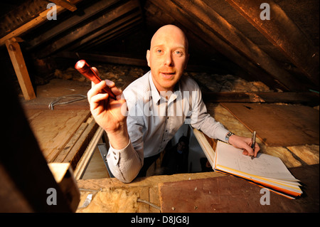 Energy Surveyor Mark Sopala inspects the loft at a domestic home in Bristol in order to optimise the heat efficiency of the hous Stock Photo