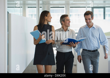 Colleagues walking and discussing documents together Stock Photo