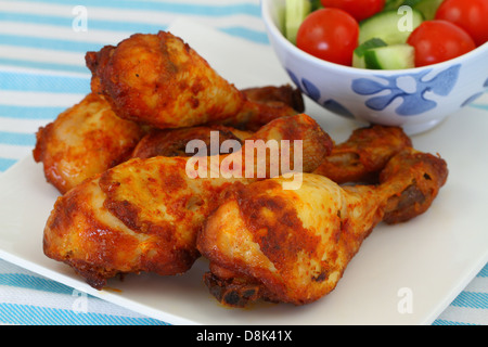 Roasted chicken drumsticks on vintage plate, close up Stock Photo