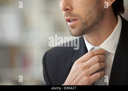 Businessman adjusting tie, cropped Stock Photo