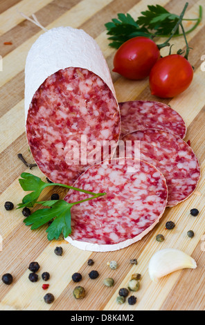 Still life with sliced romanian salami and vegetables Stock Photo