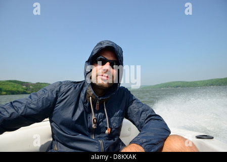 Man in a motorboat speeding away Stock Photo - Alamy