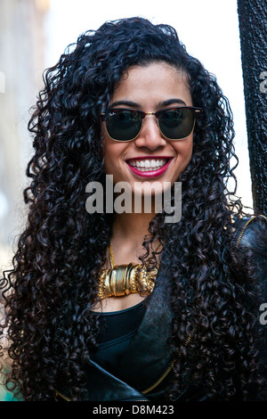 Portrait of a beautiful black woman with curly long hair, wearing sunglasses and smiling, London, England, UK. Stock Photo