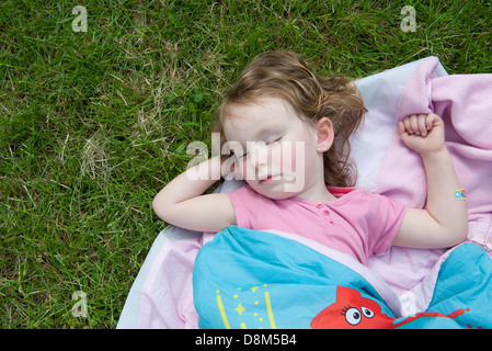Little girl napping outdoors Stock Photo