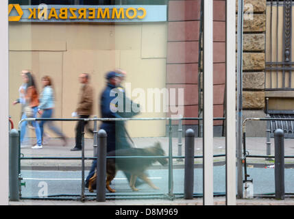 Frankfurt, Germany. 31st May 2013. A police officer passes with a dog in front of the barricaded entry of the Commerzbank in Frankfurt Main, Germany, 31 May 2013. The antiglobalization movement Blockupy is trying to interrupt business at the European Central Bank and at Frankfurt Airport today. Photo: Andreas Arnold/dpa/Alamy Live News